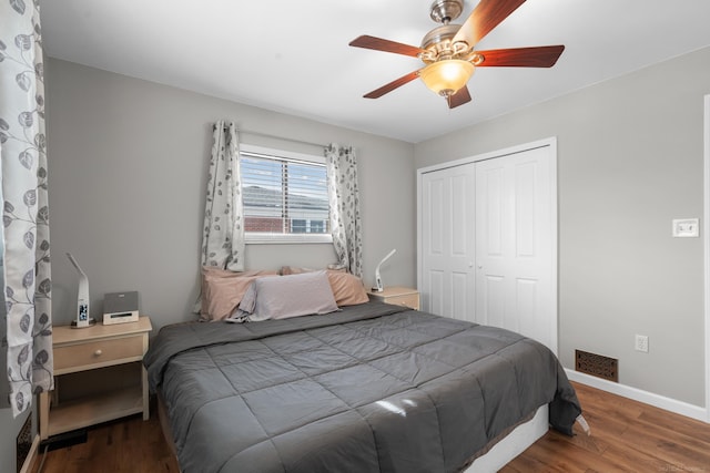 bedroom featuring dark wood-type flooring, a closet, and ceiling fan