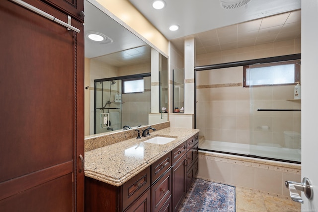 bathroom featuring vanity and shower / bath combination with glass door