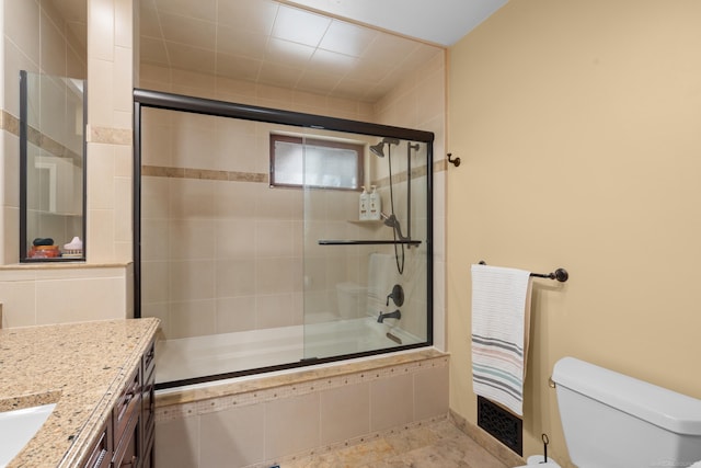 full bathroom featuring vanity, enclosed tub / shower combo, and toilet