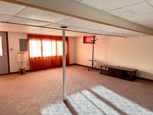 basement featuring carpet flooring, a paneled ceiling, and electric panel