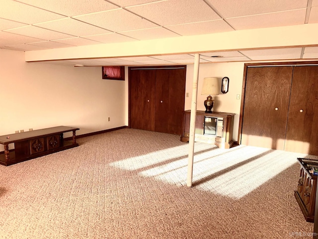 basement featuring carpet and a paneled ceiling