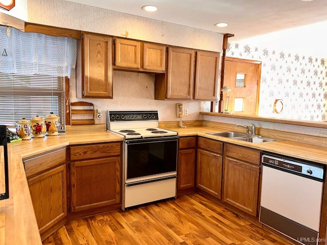 kitchen featuring sink, white appliances, and hardwood / wood-style flooring