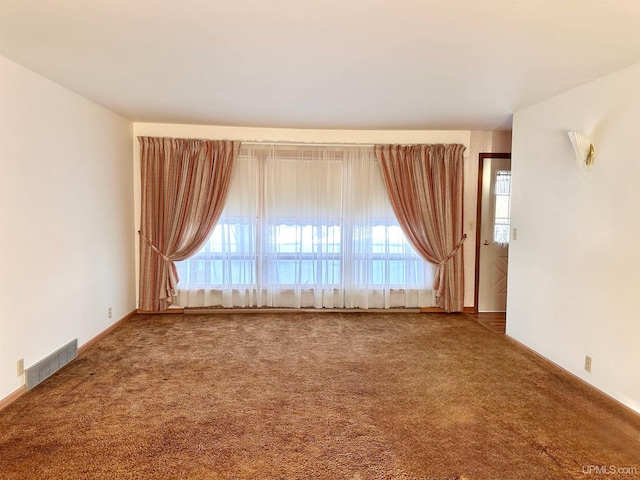 unfurnished room featuring a wealth of natural light and carpet