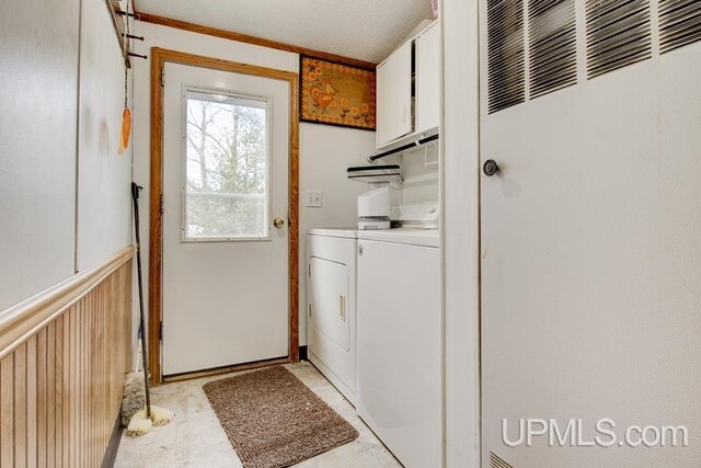 laundry room featuring cabinets and washer and clothes dryer