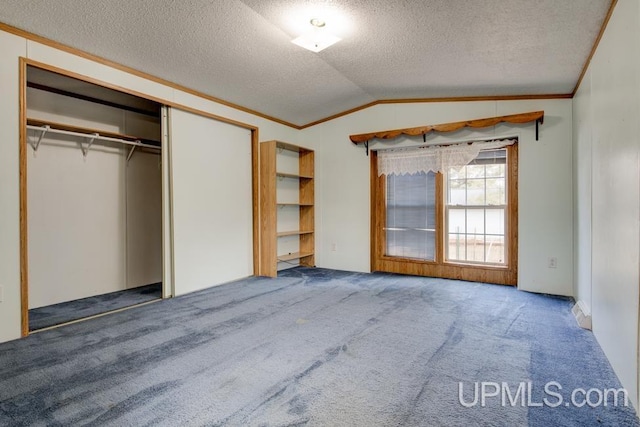 unfurnished bedroom with lofted ceiling, ornamental molding, a textured ceiling, and carpet