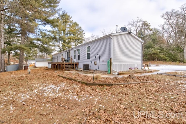 view of side of home featuring central AC unit and a wooden deck