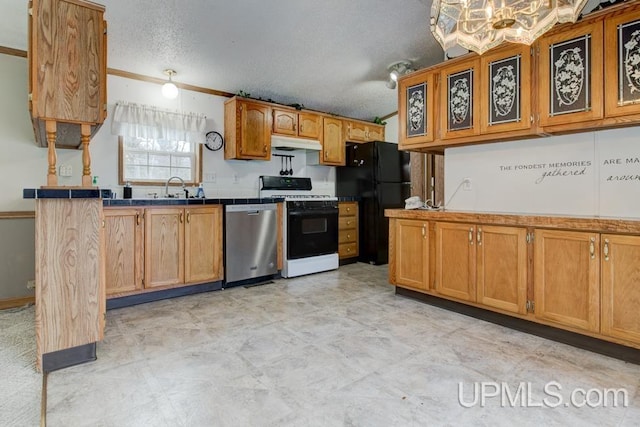 kitchen featuring sink, gas range, tile countertops, black refrigerator, and stainless steel dishwasher