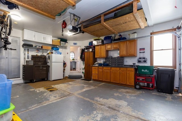 garage with a garage door opener and white refrigerator