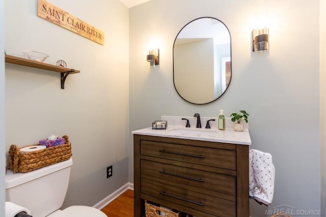 bathroom featuring vanity, hardwood / wood-style floors, and toilet