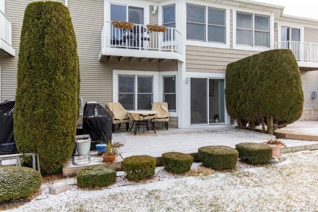 back of property featuring a balcony and a deck