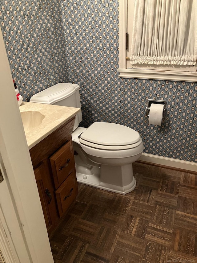 bathroom featuring vanity, parquet flooring, and toilet