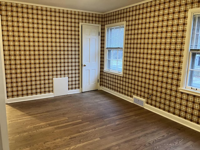 unfurnished room with ornamental molding and dark wood-type flooring