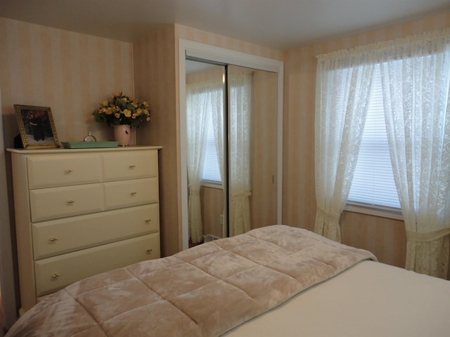 bedroom with multiple windows and a closet