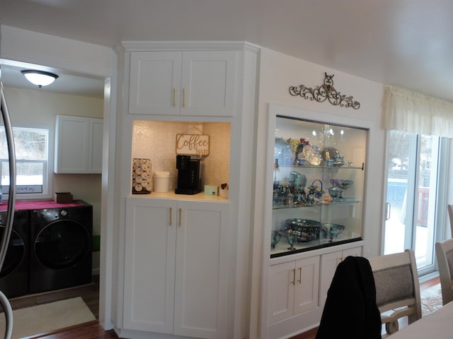 bar with white cabinetry, dark wood-type flooring, washer and dryer, and backsplash