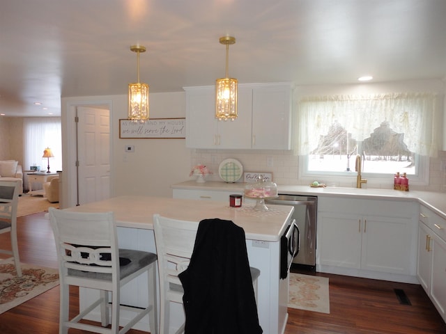 kitchen featuring pendant lighting, dark hardwood / wood-style flooring, sink, and white cabinets