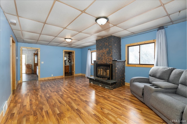 unfurnished living room featuring hardwood / wood-style floors, a paneled ceiling, and a large fireplace