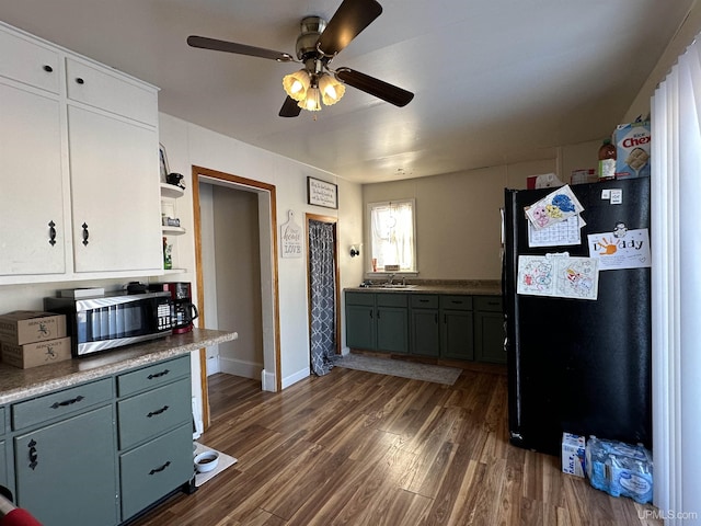 kitchen with ceiling fan, black refrigerator, sink, and dark hardwood / wood-style floors