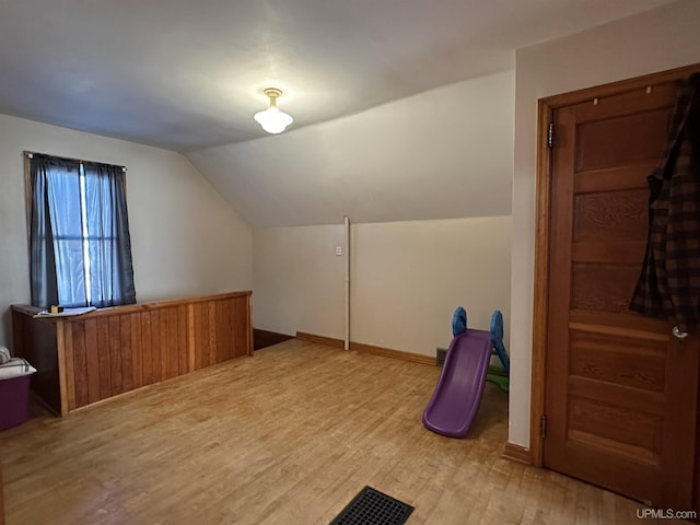 bonus room with hardwood / wood-style flooring and vaulted ceiling