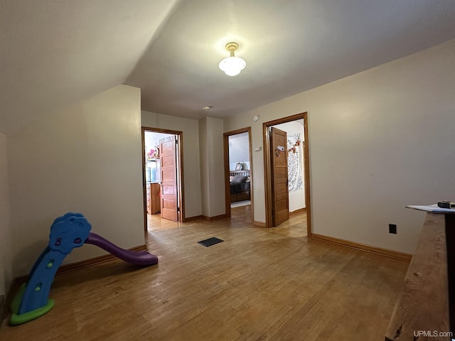 interior space with lofted ceiling and light hardwood / wood-style flooring