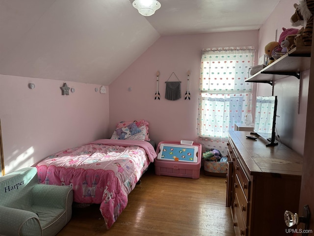 bedroom with lofted ceiling, multiple windows, and light wood-type flooring