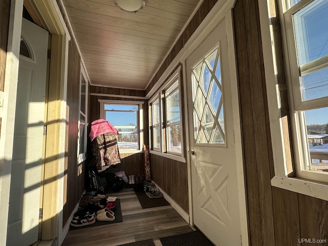 entryway with dark hardwood / wood-style floors, wooden ceiling, and wooden walls