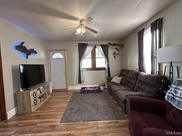 living room featuring a textured ceiling, wood-type flooring, and ceiling fan