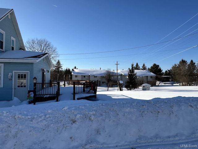 yard covered in snow with a wooden deck