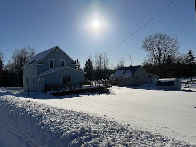 snow covered house with a wooden deck