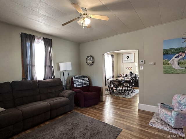 living room featuring ceiling fan and dark hardwood / wood-style flooring