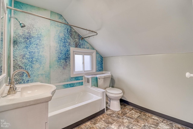 bathroom featuring lofted ceiling, vanity, a bathtub, and toilet