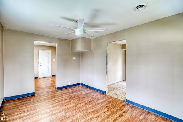 empty room with ceiling fan and light hardwood / wood-style flooring