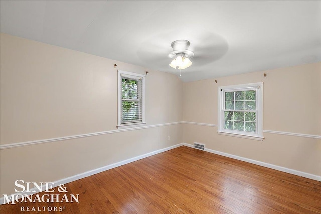 spare room featuring hardwood / wood-style floors, plenty of natural light, and ceiling fan