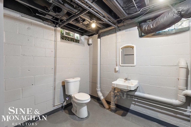 bathroom featuring sink, concrete floors, and toilet