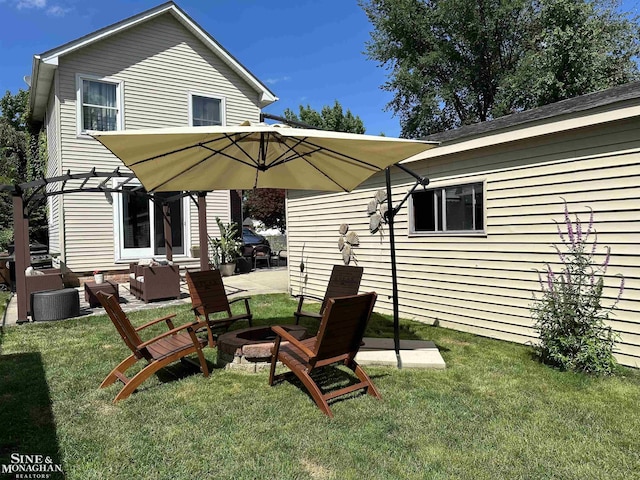 rear view of property with a fire pit, a lawn, and a patio area