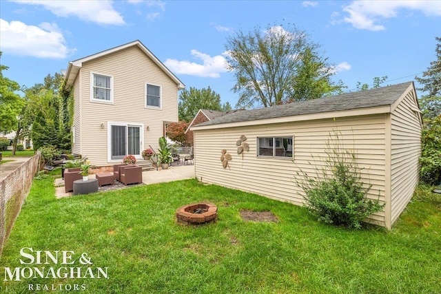 back of house with a yard, an outdoor living space with a fire pit, and a patio