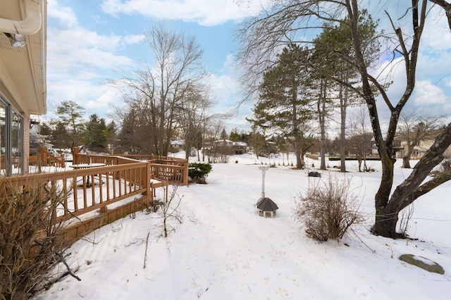 yard layered in snow featuring a deck