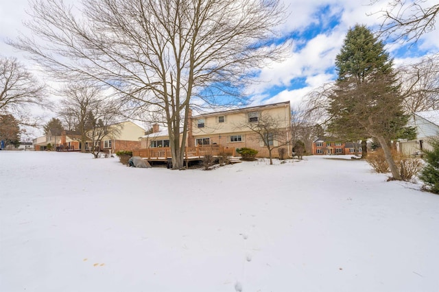 yard covered in snow featuring a deck