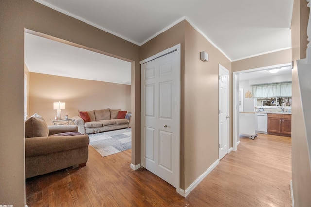 corridor featuring crown molding and light hardwood / wood-style floors