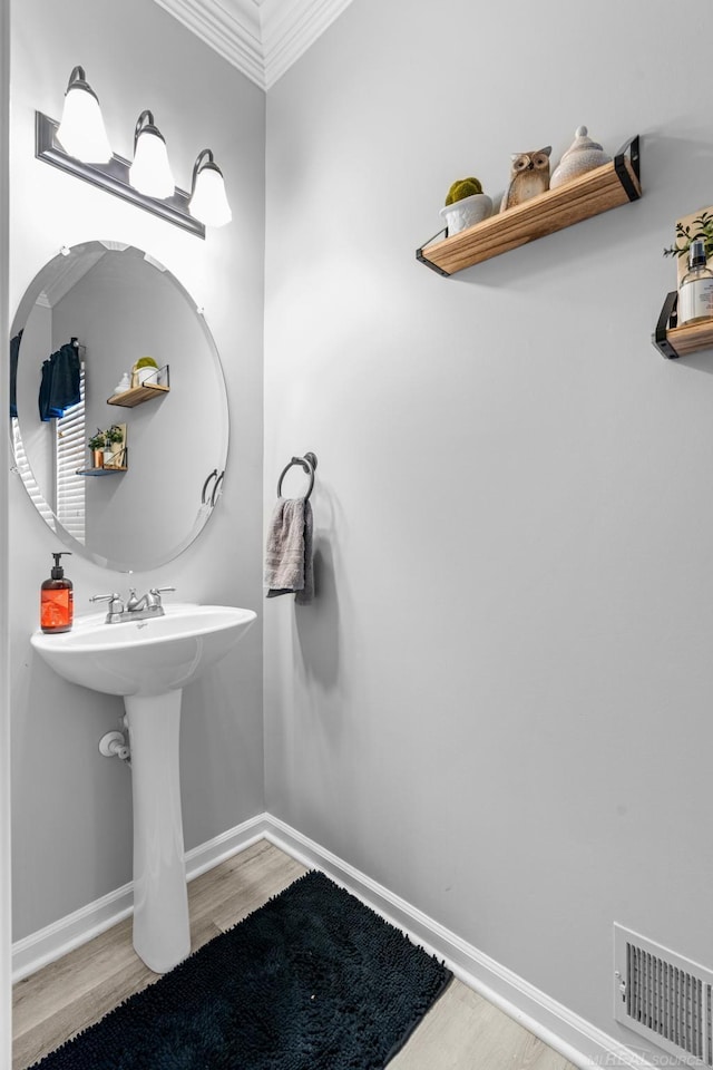 bathroom with crown molding and hardwood / wood-style flooring