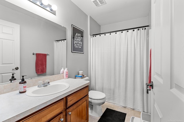 bathroom featuring vanity, tile patterned flooring, and toilet