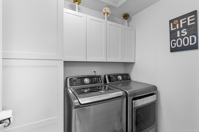 clothes washing area with cabinets and separate washer and dryer