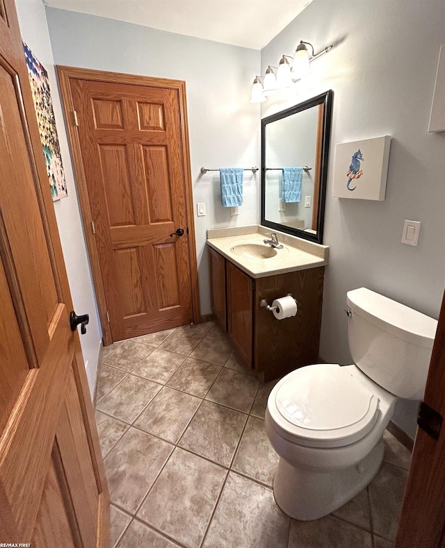 bathroom featuring vanity, tile patterned flooring, and toilet