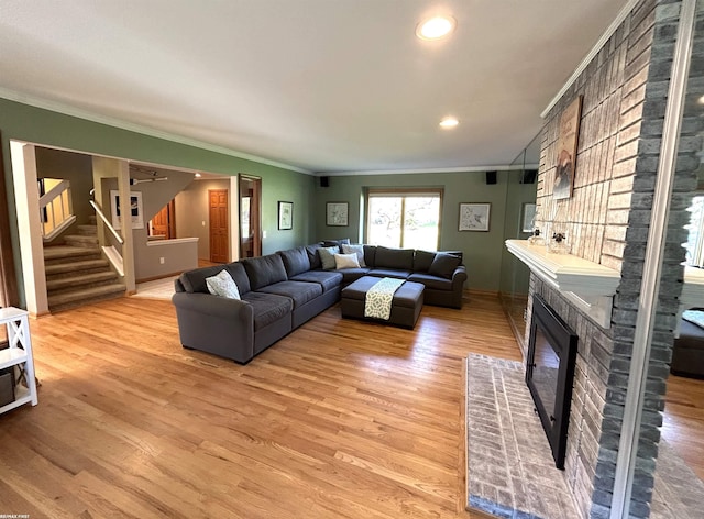 living room featuring crown molding, a fireplace, and hardwood / wood-style flooring