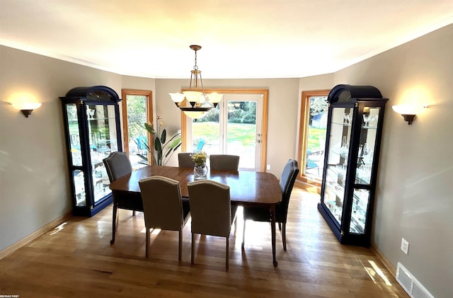 dining space with a notable chandelier and hardwood / wood-style flooring