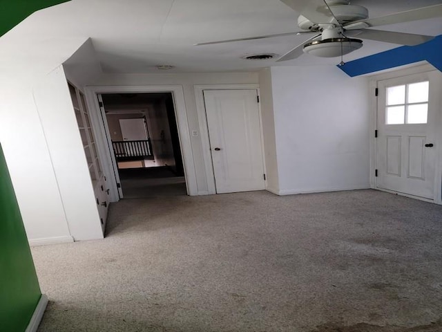 interior space with ceiling fan and light colored carpet