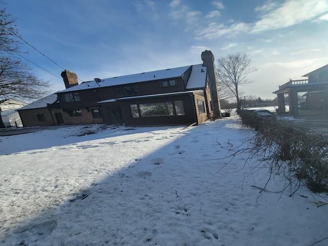 view of snow covered rear of property