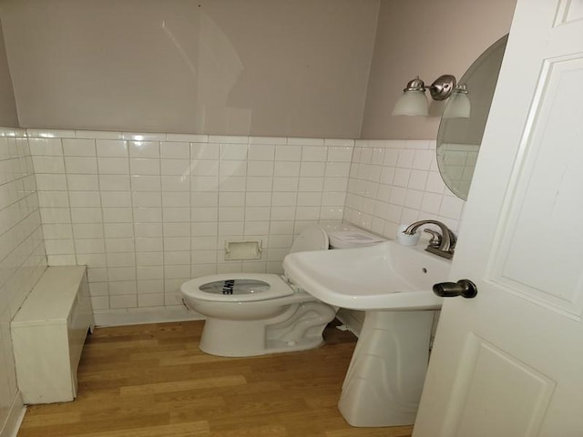 bathroom featuring sink, hardwood / wood-style floors, tile walls, and toilet