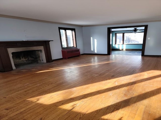 unfurnished living room featuring hardwood / wood-style floors and ornamental molding