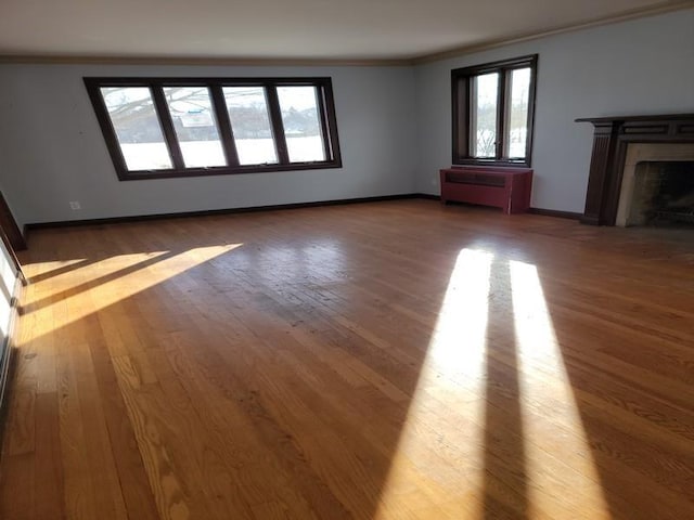 unfurnished living room with crown molding, radiator heating unit, and dark hardwood / wood-style floors