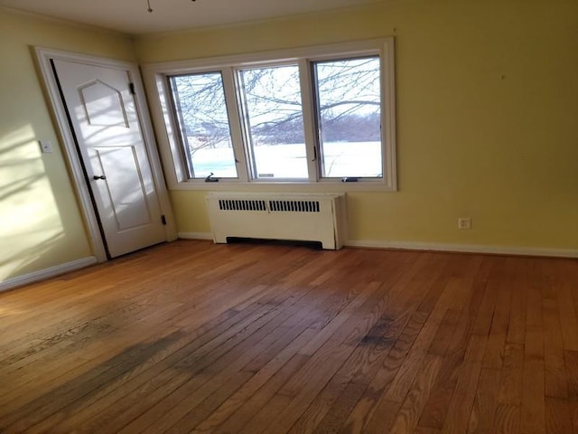 interior space with ceiling fan, radiator, and light wood-type flooring